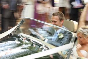 bride-and-groom-leaving-wedding-in-sports-car
