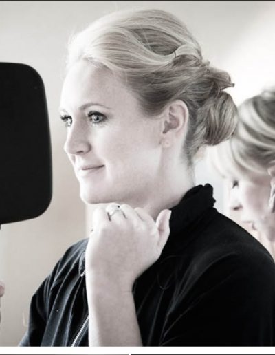 bride-looking-happily-into-the-mirror-on-her-wedding-day