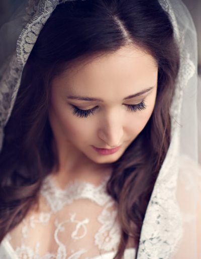 bride wearing veil looking down. perfect makeup
