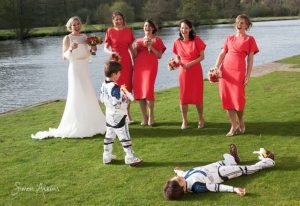 bride laughing with bridesmaids and page boys